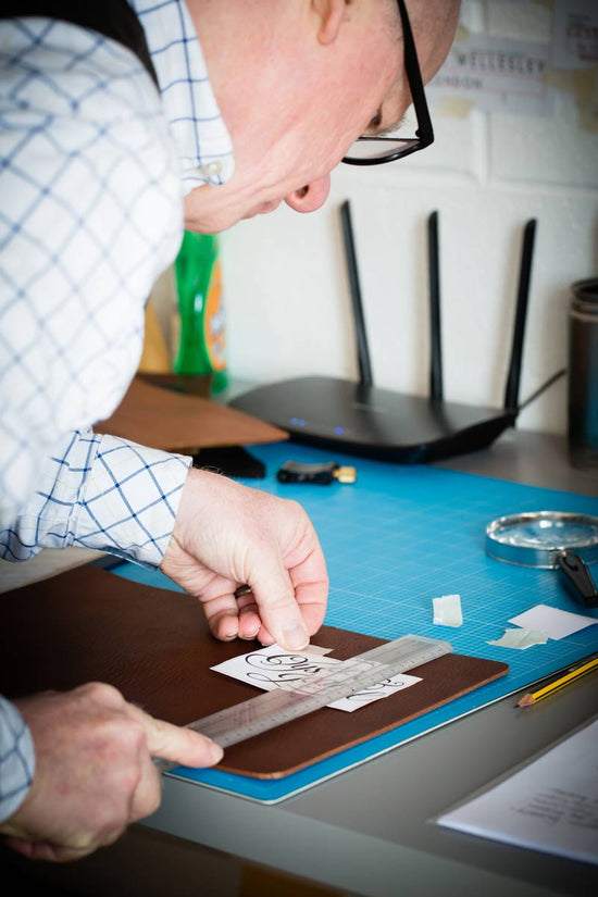 carefully measuring up where personalisation must go on a leather cover