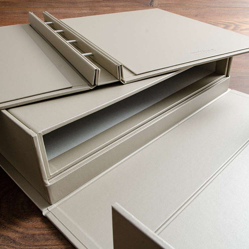 screw post binder with slipcase and clamshell box lying on wooden background