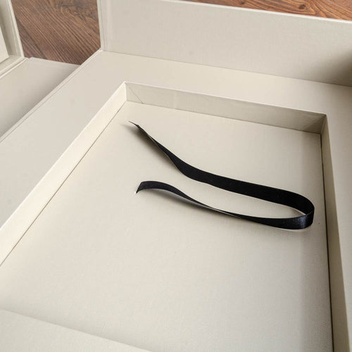 recess inside and cream coloured box with black ribbon by hartnack and company