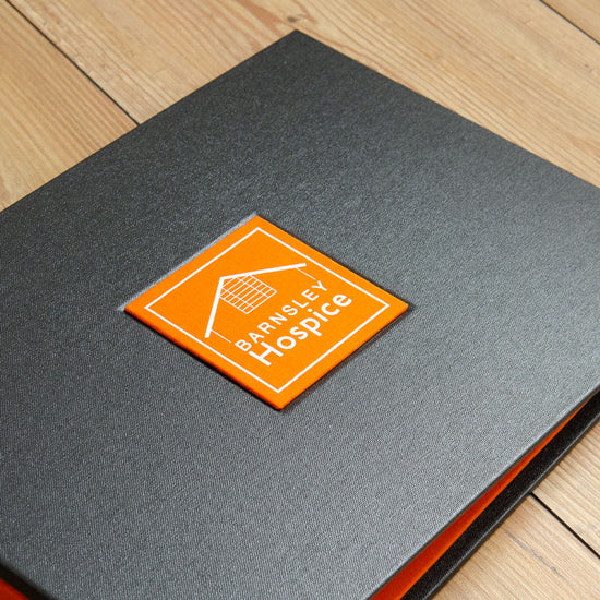 Custom made binder with orange plaque with white foil embossed lettering