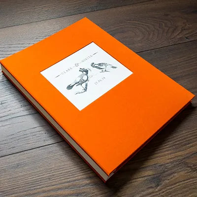 custom made orange fabric binder with inset plaque with a printed card 