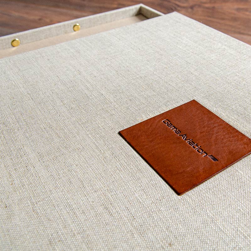 Close up of blind debossed leather plaque of company logo inset into luxury presentation box - Gallery image 4