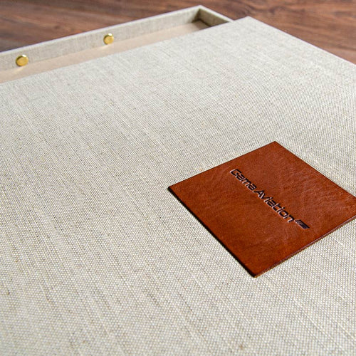 Close up of blind debossed leather plaque of company logo inset into luxury presentation box