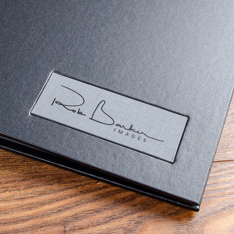grey fabric name plaque with black foil personalisation on black luxury portfolio book - Gallery image 1
