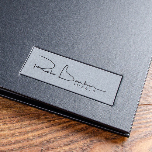 grey fabric name plaque with black foil personalisation on black luxury portfolio book