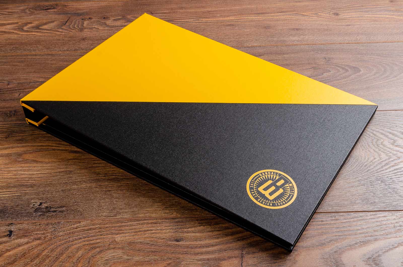 Portfolio book for graphic designer. Size is 11x17 inches. Product is hidden screw post binder. Colour is black and yellow buckram. Personalisation in fill colour UV printing