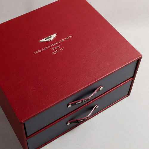 Red Leather vehicle document box file for Aston Martin DB Mark 3 with silver foil embossed cover and inset Aston Martin badge inset in the cover. The box contains a pull out drawer and personalised ring binder