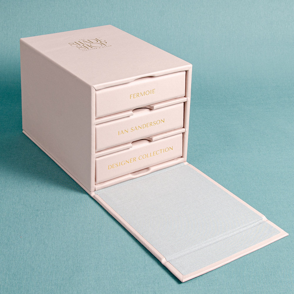 pink leather slipcase box with flap and gold embossed logo with enclosure containing three swatch books with gold foil spine - Gallery image 2