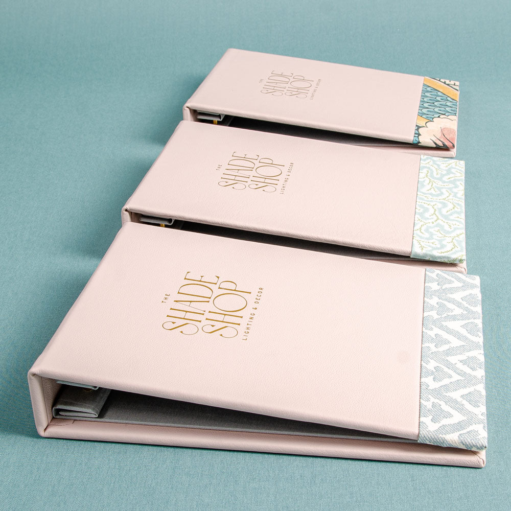 Three leather screw post binders for swatch books with Shade Shop logo foil embossed on the cover and fabric detail on he bottom of the cover - Gallery image 6