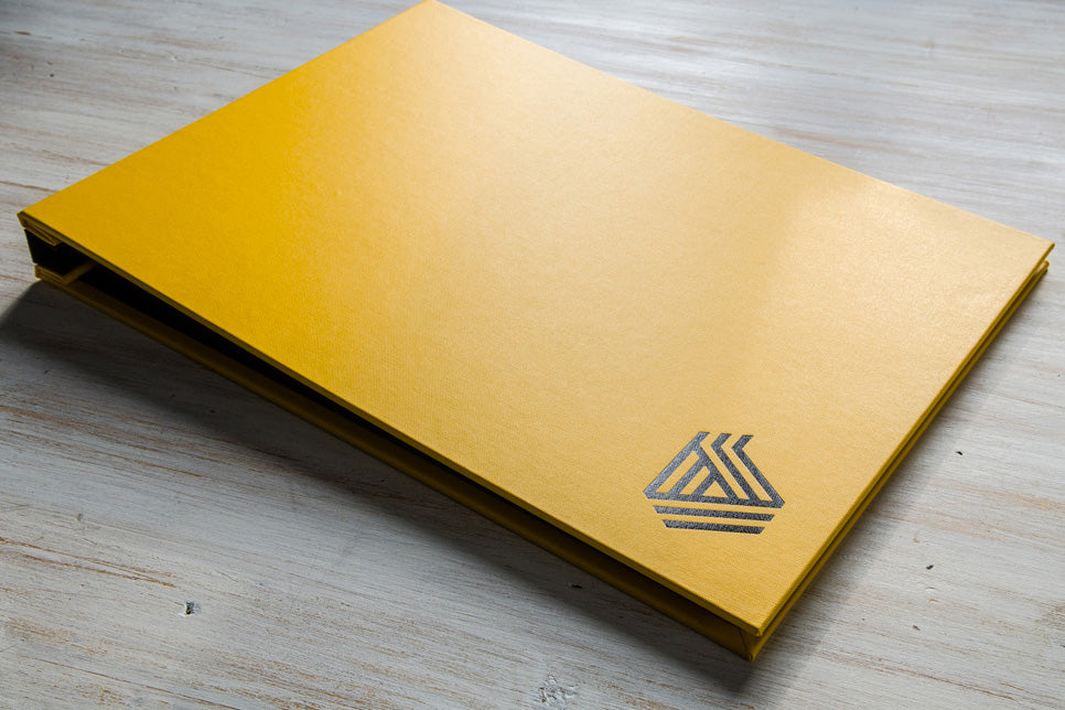 Photographers A3 portfolio book custom made in yellow buckram with logo foiled in black on the cover