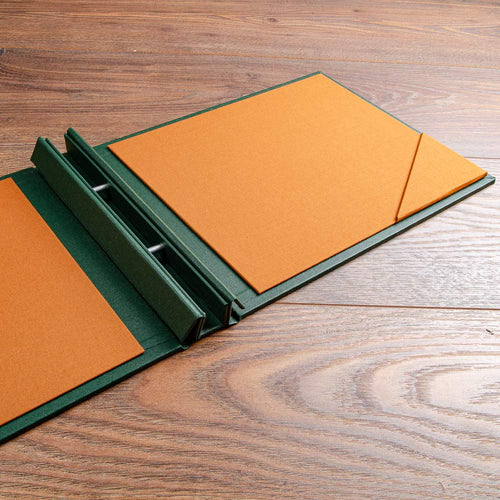 a4 screw post binder with copper coloured inner covers with corner pockets on wooden background