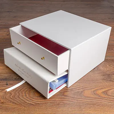 white keepsake box with drawer and white leather binder with gold foil embossing