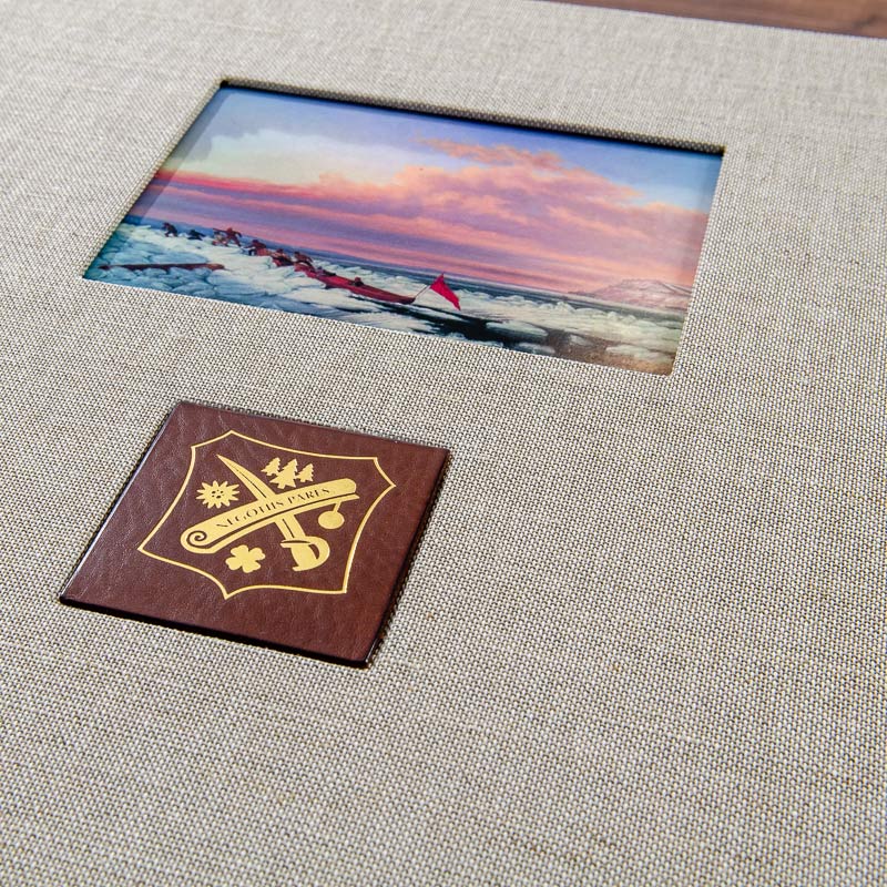close up of personalised clamshell box with window in the cover for a picture and brown leather plaque with a logo gold foiled onto it - Gallery image 5