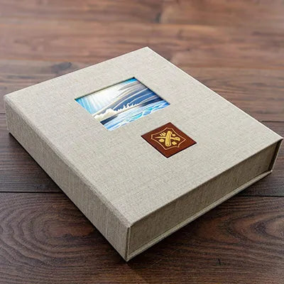 custom made luxury clamshell presentation box personalised with a picture of sunset painting inset into the cover and gold embossed logo on leather plaque