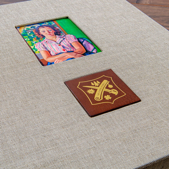brown leather gold foiled logo and mounted picture in he cover of a custom made box
