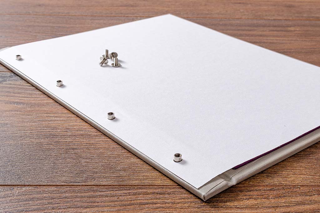 Place your page onto the cover. The screw post spacing is based on a standard 4 hole paper punch or in the case of US sizes, 3 hole.