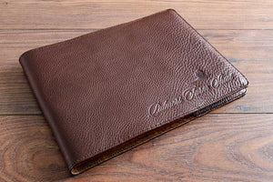 Leather book cover jacket in 2.5mm dark brown leather with blind debossed personalised logo in the bottom right hand corner